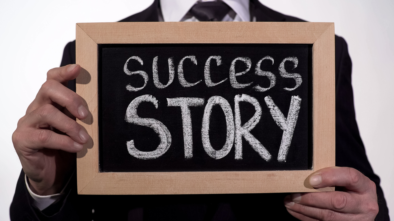 Success story written on blackboard in businessman hands, start new business